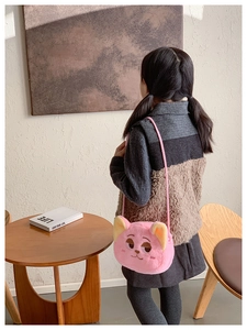 Detail of a pink plush cartoon fox crossbody bag for kids with soft fur and embroidery