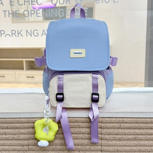 Détail du sac à dos enfant lavande et beige avec doubles boucles et breloque fleurie