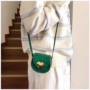 Détail du mini sac vert effet crocodile avec boucle cœur dorée et fine bandoulière