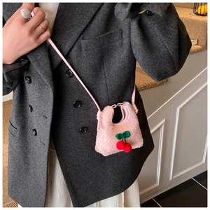 Close-up of pink plush cherry shoulder bag with soft fleece texture and cute leaf detail