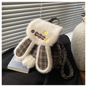 Detail view of cute plush rabbit backpack with white faux fur ears and fluffy pom-pom tail