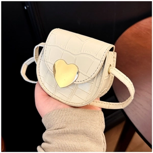 Détail du mini sac crème avec texture pierre et boucle en métal doré en forme de cœur