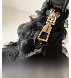 Gros plan sur la fermeture éclair dorée polie sur un sac en tulle plissé noir