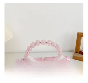 Détail du sac à paillettes rose pour fille avec nœud en soie et poignée perlée