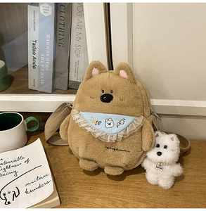 Detail of brown plush bear crossbody bag with cute blue bib and white dog pendant charm