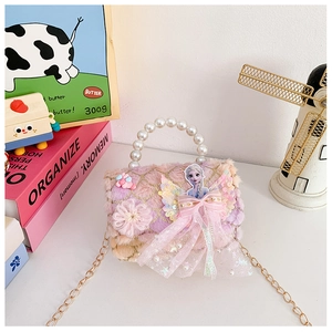 Detail of plush bear purse featuring Elsa patch, pearl handle and golden chain strap