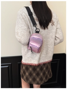 Dettaglio della mini borsa a tracolla olografica rosa indossata da un bambino alla moda