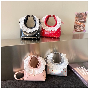 Detailed view of polka dot mini bags with white embroidery lace trim and metal handles