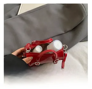 Détail montrant la capacité intérieure d'un mini sac cylindrique en cuir verni rouge zippé