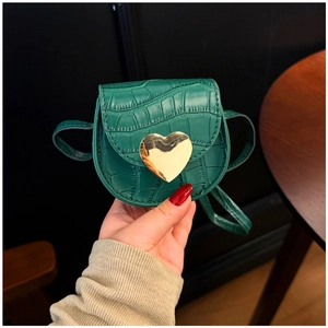Gros plan du mini sac vert gaufré crocodile avec boucle cœur en métal doré
