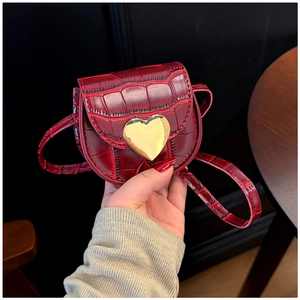 Détail du mini sac rouge à texture crocodile avec boucle métallique dorée en forme de cœur