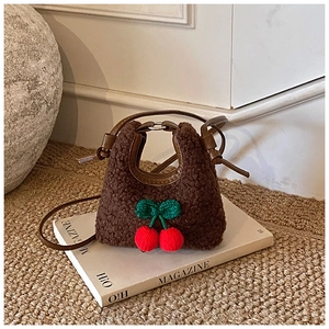 Close-up of brown plush mini bag featuring 3D knitted cherry decor and leather straps