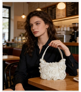 Détail des pétales de roses 3D blanches sur le sac de soirée élégant en tulle à poignée