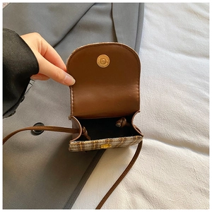 Detail of plaid mini crossbody bag with brown faux leather flap and magnetic closure