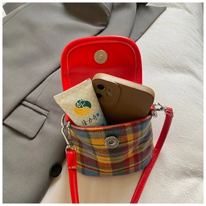 Détail du mini sac seau à carreaux montrant l'intérieur pour téléphone et crème