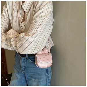 Détail du mini sac bandoulière rose avec broderie cœur, nœud et dentelle pour filles