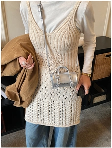 Détail d'un mini sac cylindre argenté avec boucles porté par un jeune enfant