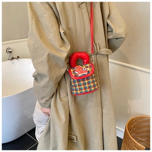 Détail du sac en tweed pour fille avec écusson cheval rouge dans un cadre de vie