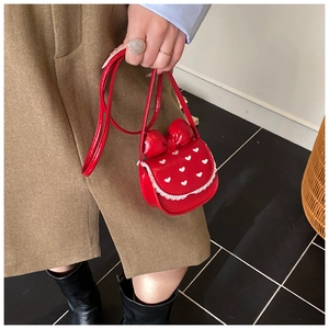 Détail du sac bandoulière rouge pour enfant en cuir avec nœud et dentelle