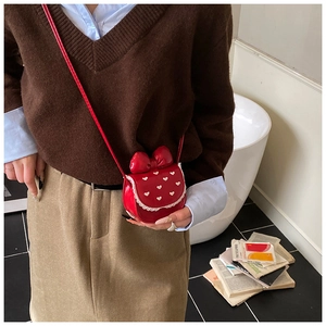 Sac à bandoulière rouge pour fille avec nœud et broderie cœur en situation réelle