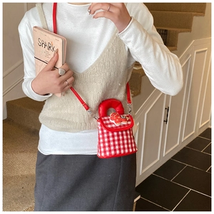 Détail d'un sac à carreaux rouge pour fille avec poney de dessin animé sur mannequin
