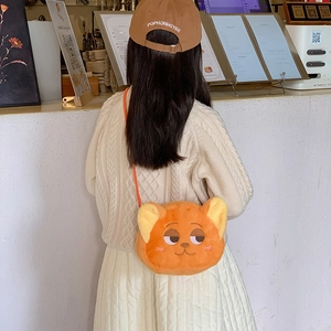 Cute orange plush cartoon fox crossbody bag for kids shown in a cozy cafe setting