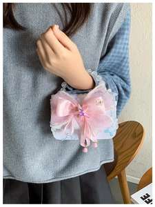 Détail de paillettes et grand nœud rose sur sac à main en dentelle pour fille