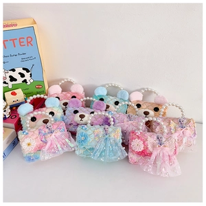 Detail of plush children's handbag with faux pearl handle and colorful princess patch
