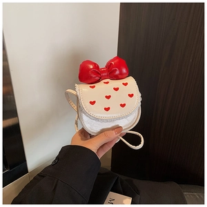Vue détaillée du sac blanc pour enfant avec nœud rouge et broderie cœur