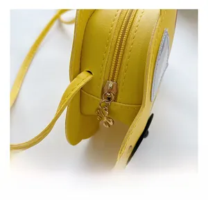 Detail of the golden flower zipper on a cartoon yellow PU leather kids crossbody bag