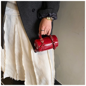 Vue détaillée du mini sac cylindre rouge avec motif Hello jm et finition cuir verni brillant