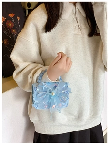 Détails macro de paillettes bleues, nœud en organza et perle sur le mini sac pour fille