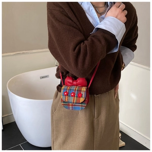 Toddler plaid crossbody bag featuring red bow and 3D flowers shown on a model
