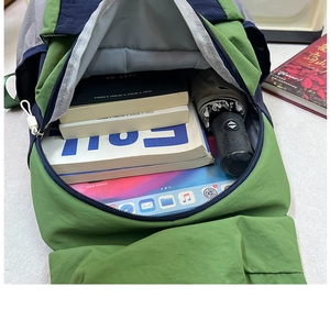 Top view of spacious multi-color school backpack showing interior with tablet and books