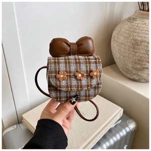 Close-up of checkered crossbody bag with large brown bow and floral details