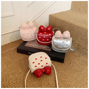 Close-up of girls bow handbags with heart embroidery and lace trim details