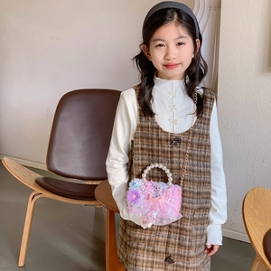 Girl wearing plaid vest dress with plush pink princess handbag featuring pearl handle