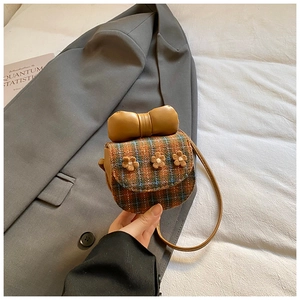 Close-up of mini checkered crossbody bag with 3D floral accents and a large leather bow