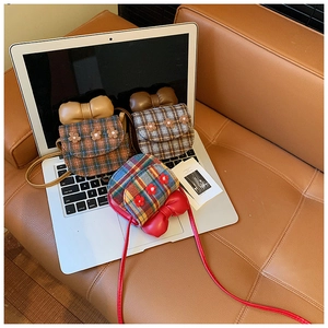 Close-up of mini plaid crossbody bags with 3D flower decor and bow on a laptop