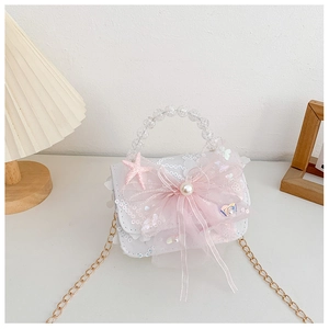 Détail du nœud en dentelle rose, de la perle et des paillettes sur le sac blanc pour fille