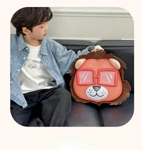 Detail of cute orange lion backpack with red glasses shown with a child on a sofa