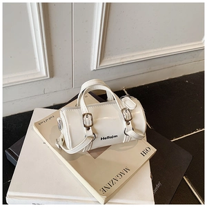 Détail du mini sac cylindrique blanc avec lettrage Hellojm et texture en cuir brillant