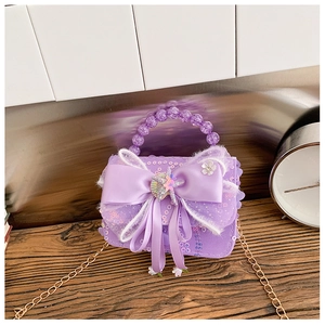Détail du sac à main violet à paillettes pour enfant avec nœud et poignée perle