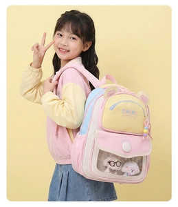 Pink and yellow cartoon backpack for kids featuring transparent pocket with plush dog charms