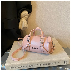 Vue détaillée du sac cylindrique rose avec inscription Hellojm et boucle en métal fine