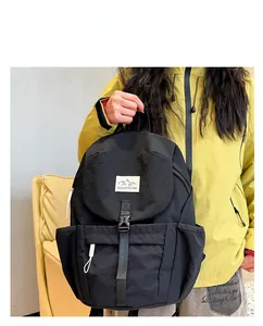 Detail of black nylon backpack with MOUNTAINS patch and quick-release buckle strap