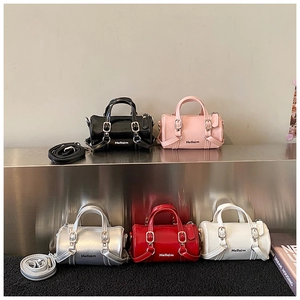 Gros plan sur cinq mini sacs cylindriques en cuir PU noir, rose, argent, rouge et blanc
