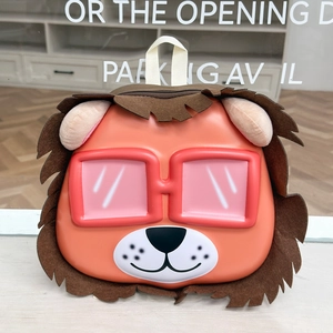 Detail of cute lion backpack with pink glasses and felt mane on an orange EVA shell