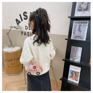 Pink cartoon police car crossbody bag for kids shown on a little model in a cozy studio