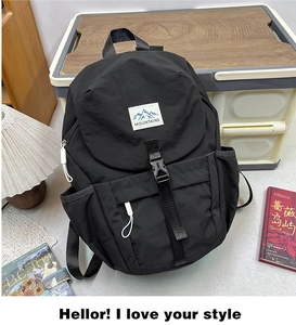 Detail view of the black waterproof nylon backpack with buckle strap and mountain label